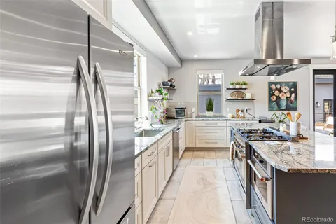 a kitchen with stainless steel appliances granite countertop a refrigerator and a stove