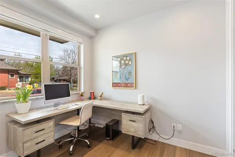 a view of a workspace with furniture and a window