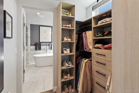 a view of walk in closet with clothes and shoes