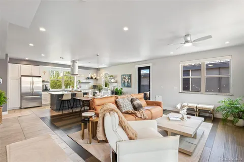 a living room with furniture large window and wooden floor