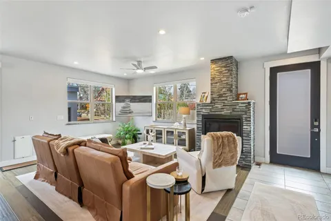 a living room with furniture a fireplace and a large window