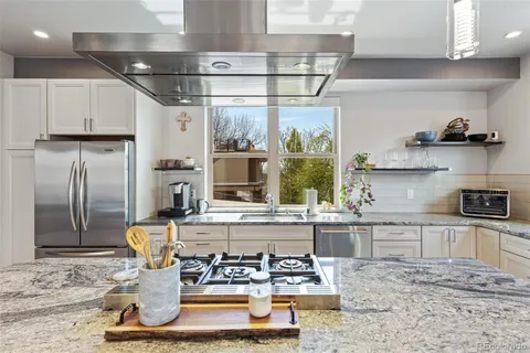 a kitchen with stainless steel appliances granite countertop a sink and a refrigerator
