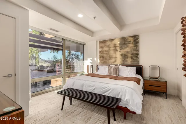 a bedroom with a bed and a large window