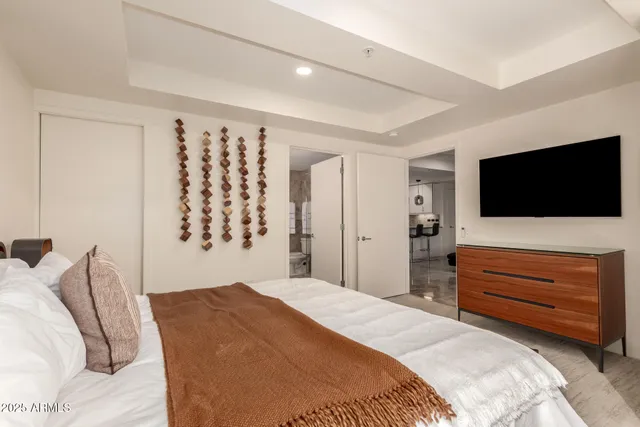 a bedroom with a bed and a flat screen tv