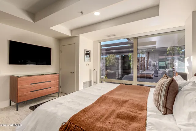 a bedroom with a bed and a flat screen tv