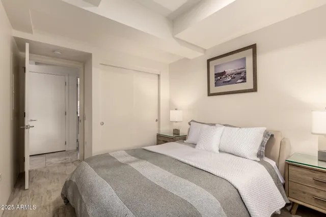 a bedroom with a bed and painting on the wall