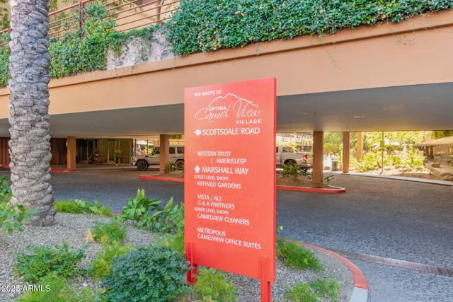 a patio with table and chairs and potted plants