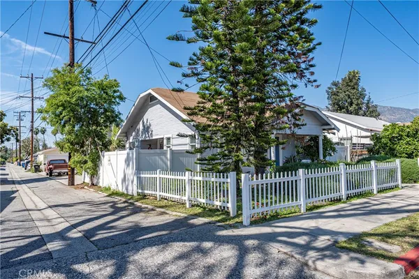 a view of a house with a small yard and wooden fence