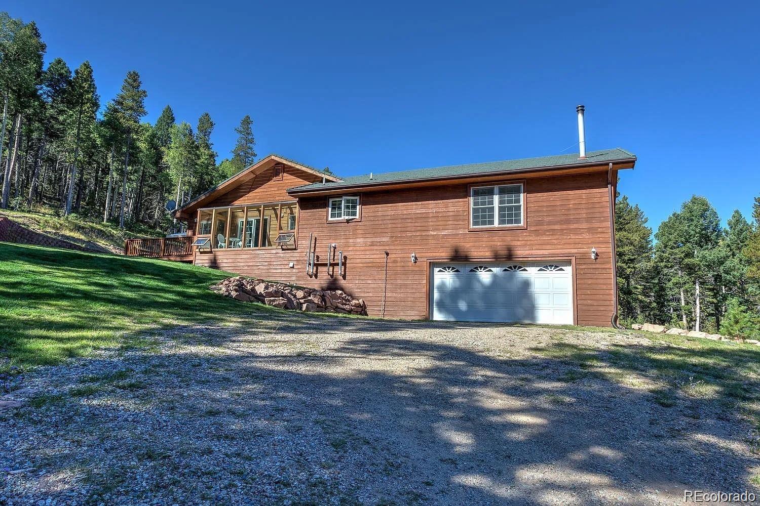 29469 County Road Fort Garland, CO 81133 - Photo 24 of 36 a front view of a house with a yard and garage