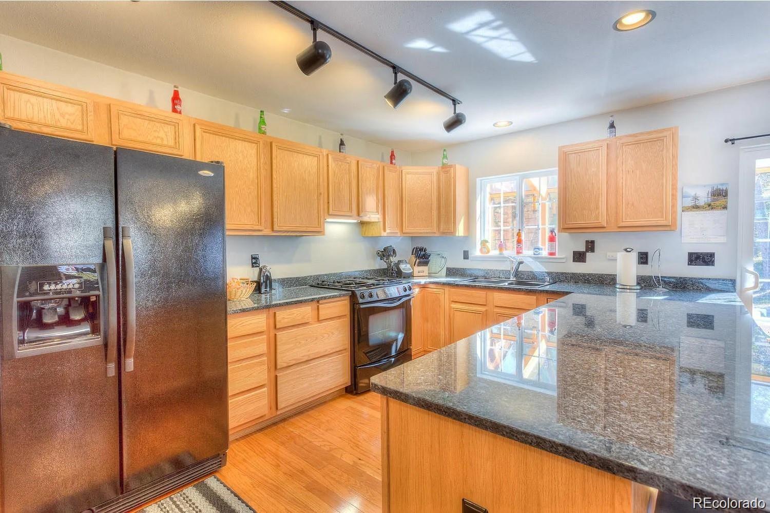 29469 County Road Fort Garland, CO 81133 - Photo 5 of 36 a kitchen with stainless steel appliances granite countertop a refrigerator a sink and white cabinets