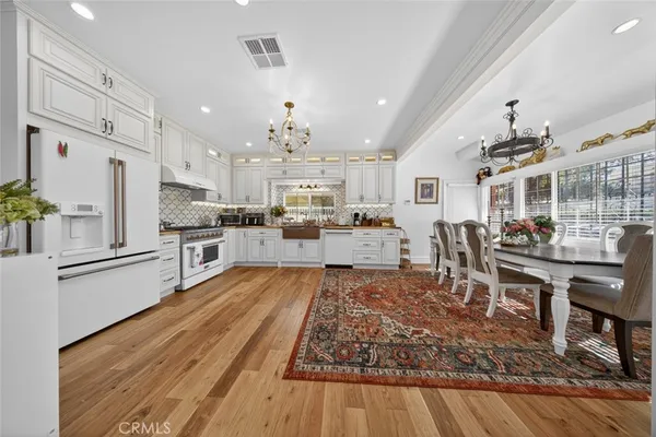 a living room with stainless steel appliances kitchen island granite countertop furniture wooden floor and a view of kitchen