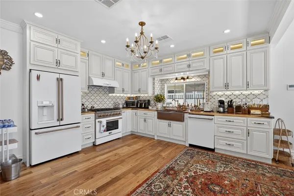 a kitchen with granite countertop stainless steel appliances and white cabinets