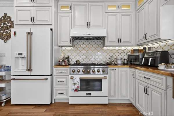 a kitchen with granite countertop white cabinets and white appliances