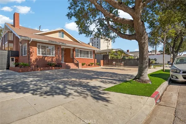 a front view of a house with a yard and potted plants