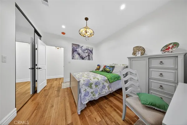 a view of a bedroom with furniture and wooden floor