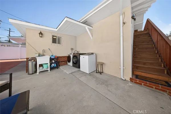 a view of a storage & utility room with stairs fridge