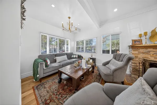 a living room with furniture a fireplace and a chandelier