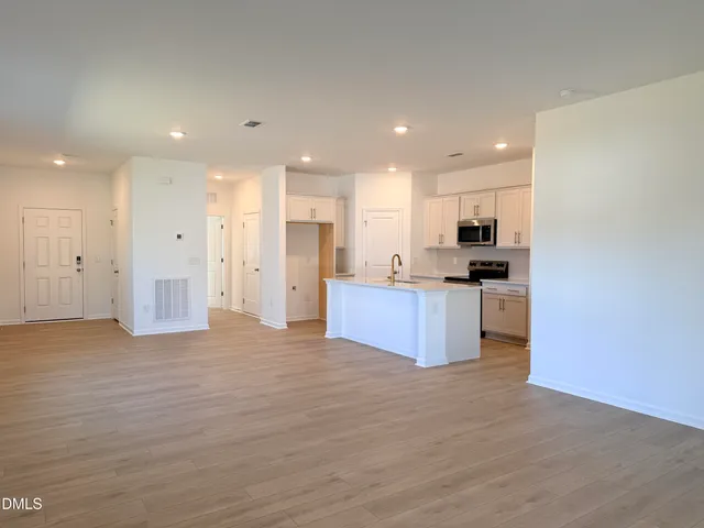 a view of kitchen with kitchen island wooden cabinets and refrigerator