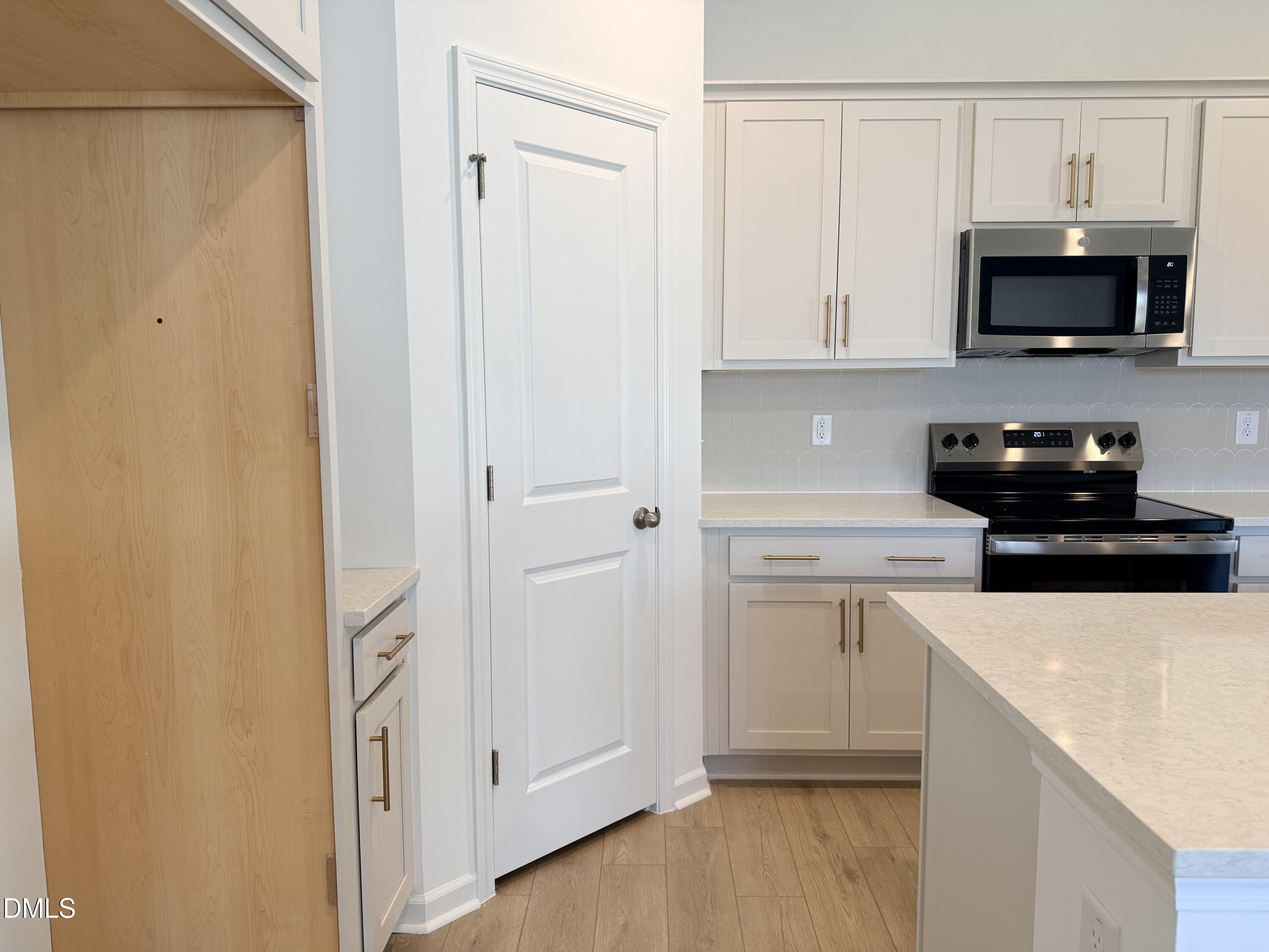 11804 Salers Loop Middlesex, NC 27557 - Photo 5 of 31 a kitchen with stainless steel appliances a sink a stove a microwave and cabinets