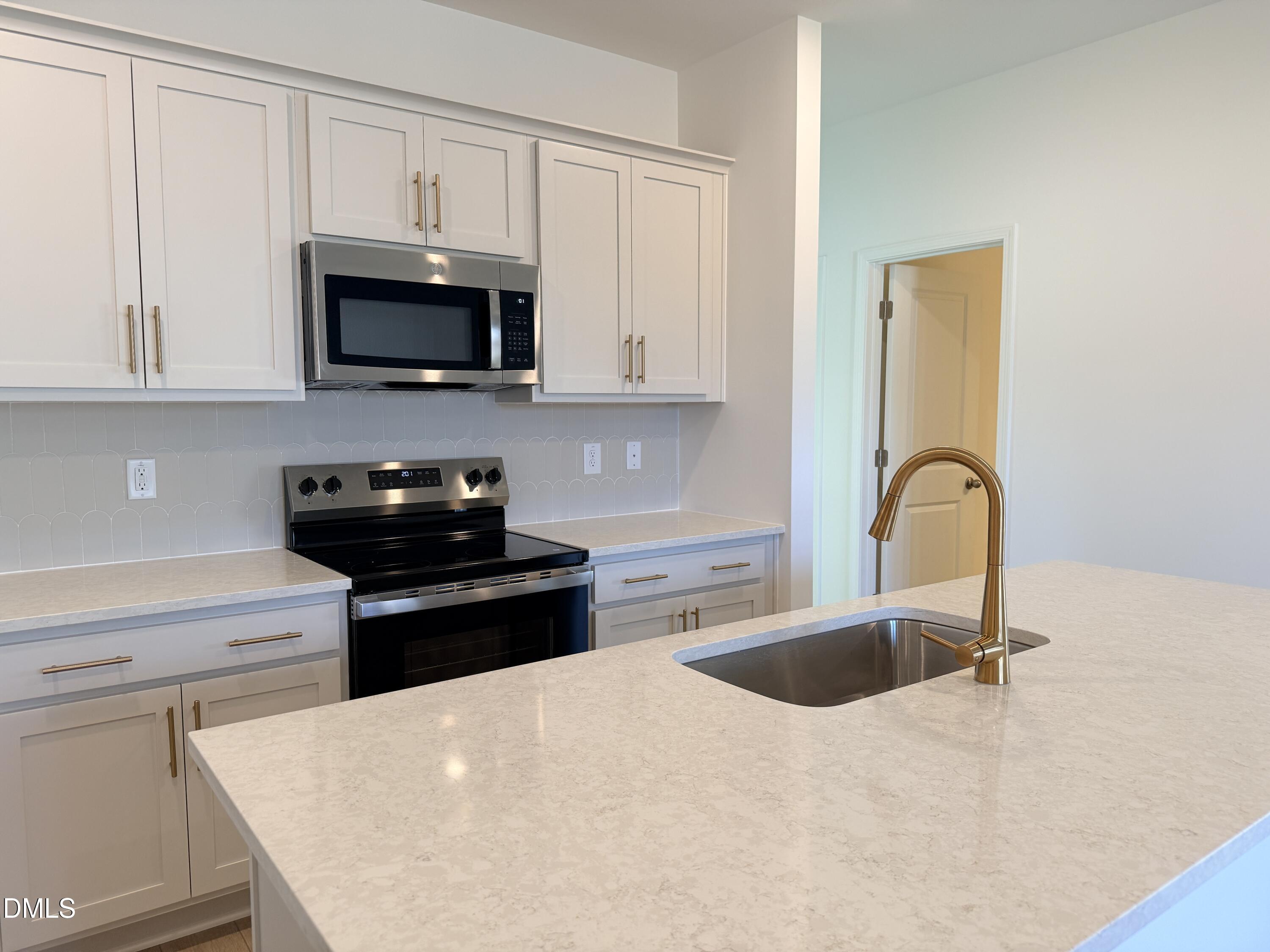 11804 Salers Loop Middlesex, NC 27557 - Photo 6 of 31 a kitchen with stainless steel appliances granite countertop a sink a stove top oven and white cabinets