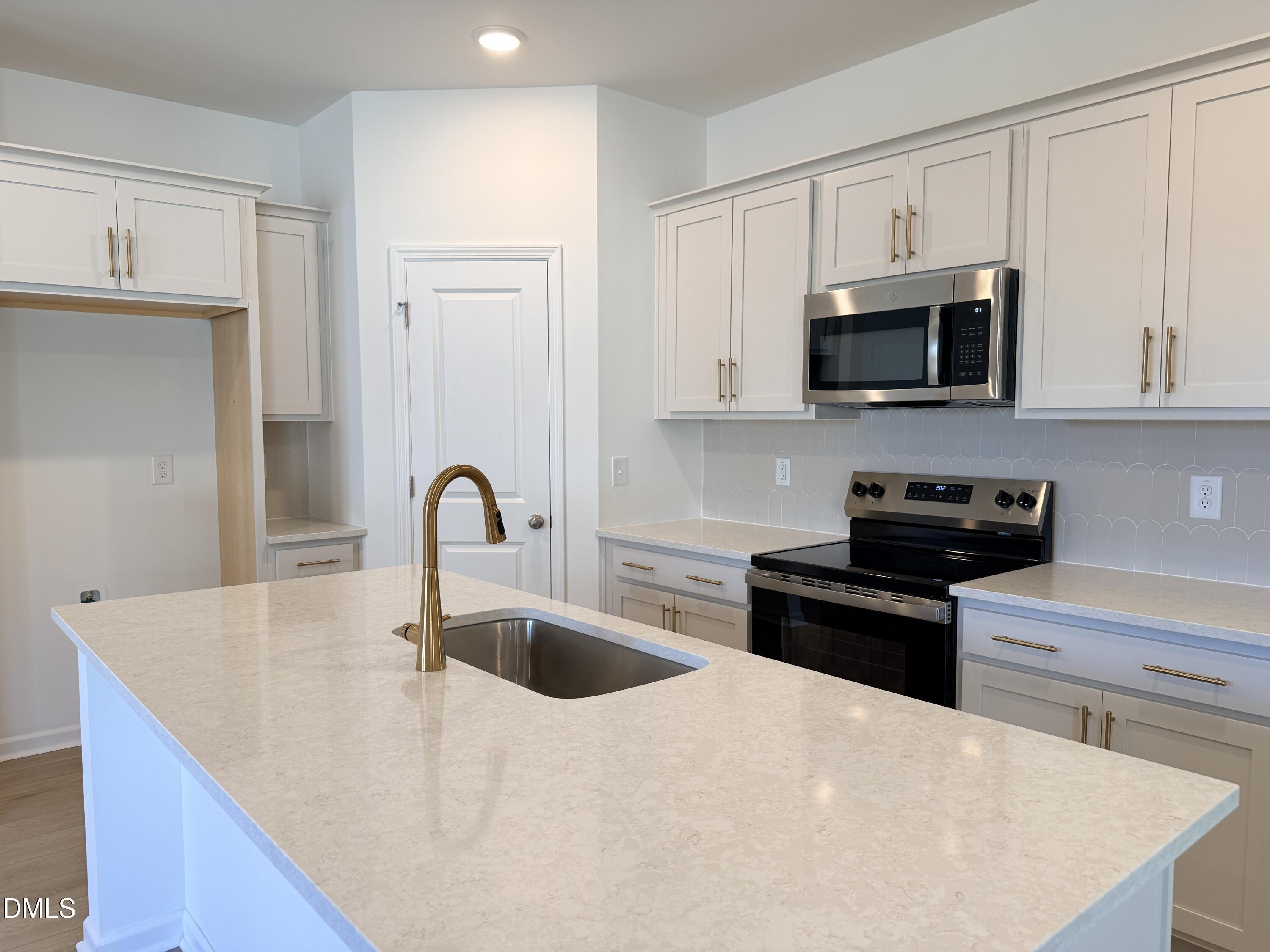 11804 Salers Loop Middlesex, NC 27557 - Photo 8 of 31 a kitchen with stainless steel appliances granite countertop a sink a stove top oven and white cabinets