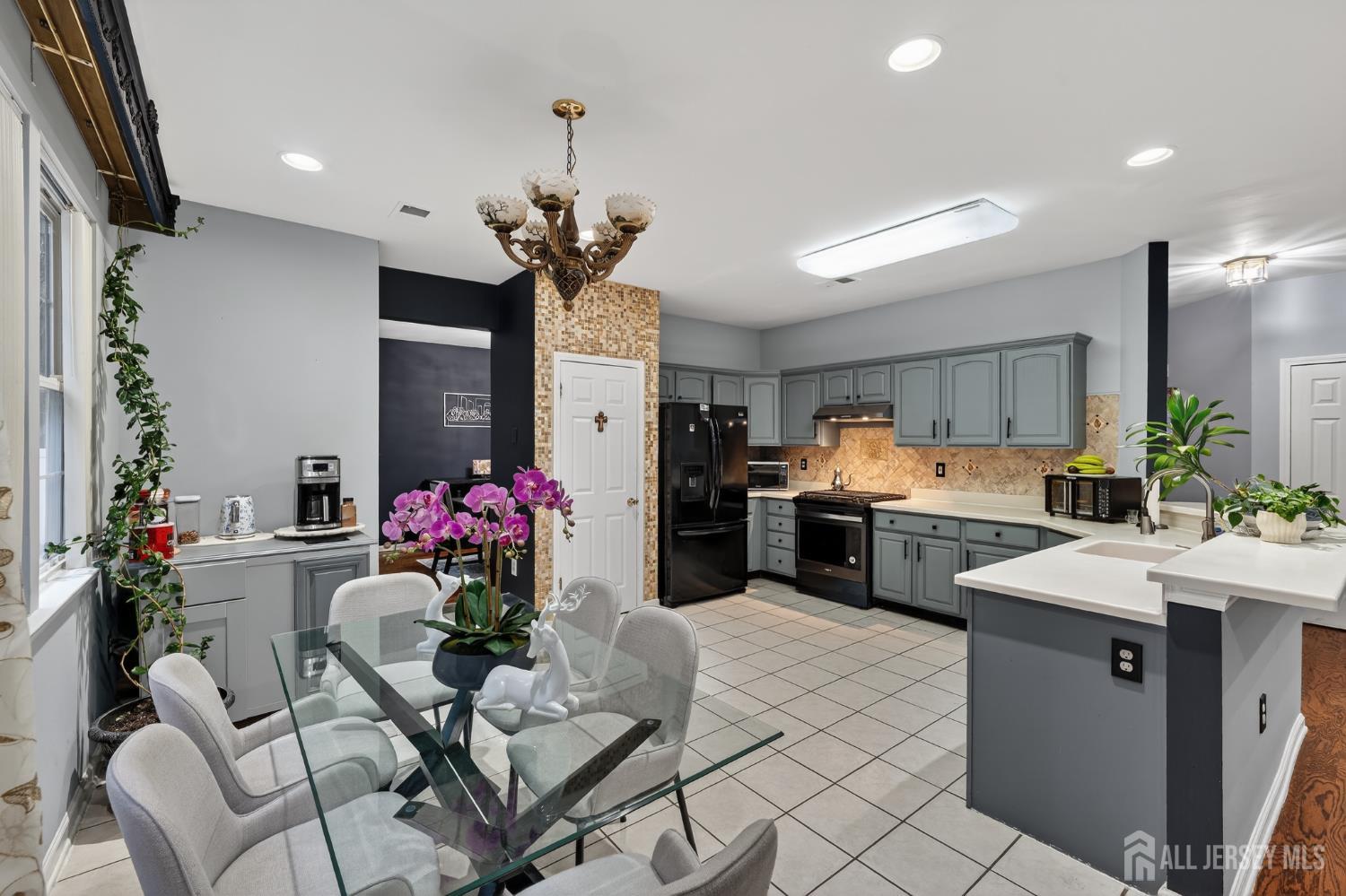 351 Wedgewood Road Morganville, NJ 07751 - Photo 45 of 74 a kitchen with stainless steel appliances kitchen island granite countertop a sink dishwasher a stove a refrigerator and a dining table with wooden floor