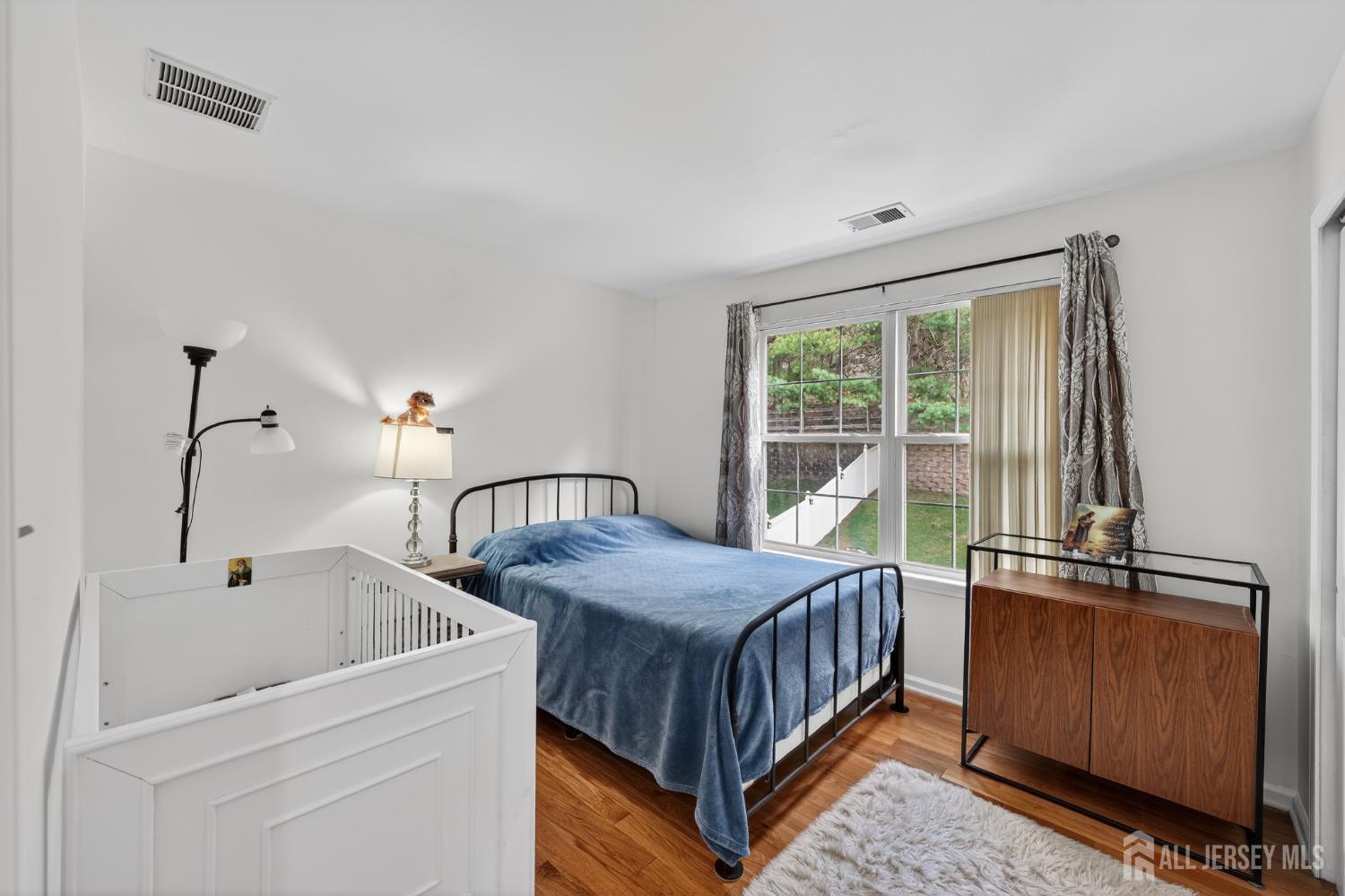 351 Wedgewood Road Morganville, NJ 07751 - Photo 71 of 74 a bedroom with a bed and wooden floor