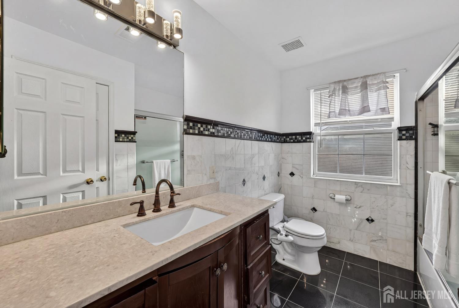 351 Wedgewood Road Morganville, NJ 07751 - Photo 73 of 74 a bathroom with a double vanity sink a toilet and a mirror