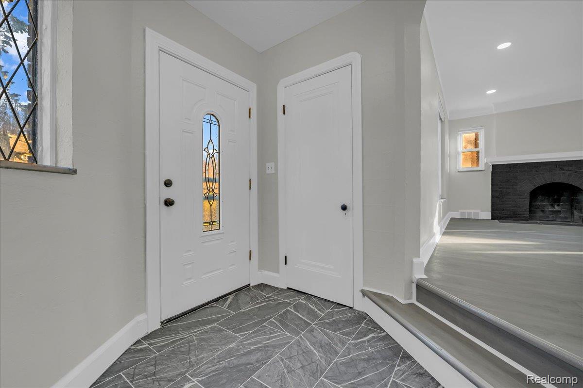 16717 Fielding Street Detroit, MI 48219 - Photo 5 of 46 Foyer entrance featuring marble look tile flooring, a fireplace, and recessed lighting