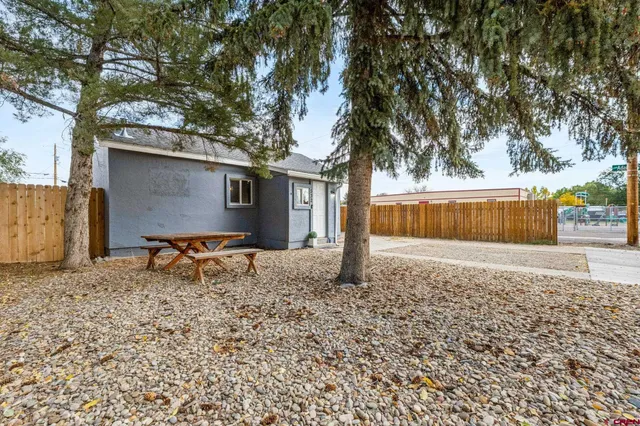 a backyard of a house with table and chairs