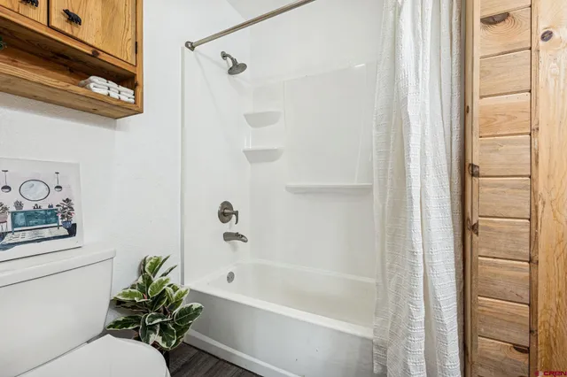 a bathroom with a shower a toilet and a sink