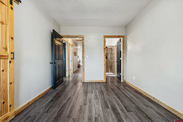 a view of a room with wooden floor and a window