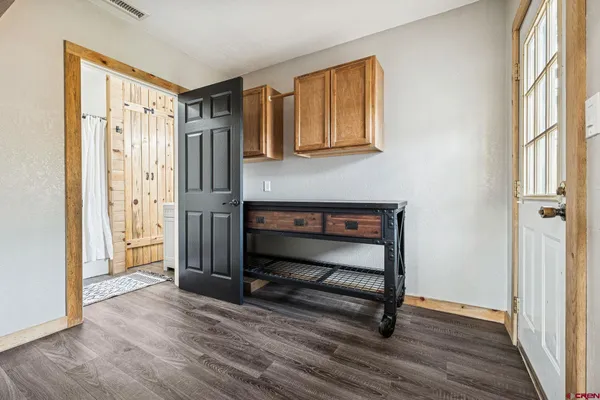 a view of front door with wooden floor and cabinet
