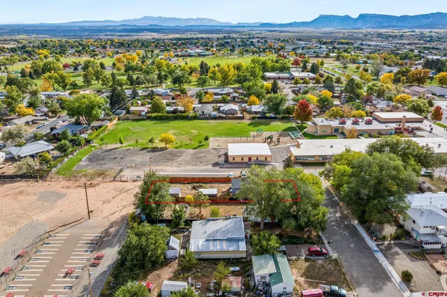 an aerial view of a city with lots of residential buildings and mountain view in back