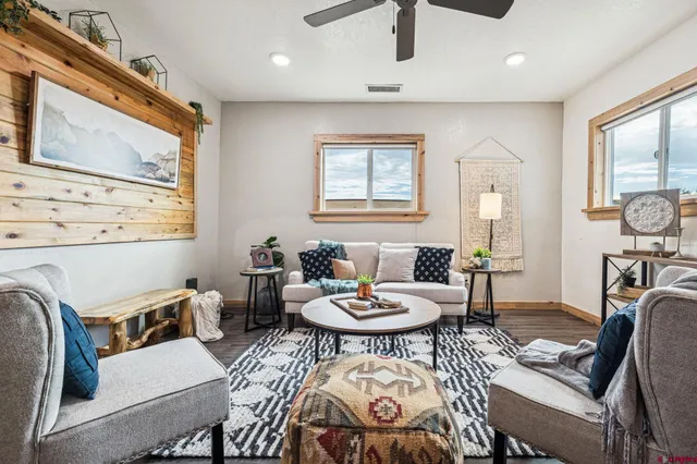a living room with furniture a wooden floor and a large window