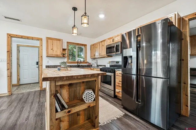 a kitchen with kitchen island a counter top space stainless steel appliances and cabinets