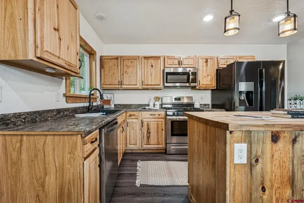 a kitchen with stainless steel appliances granite countertop a stove a sink and a refrigerator