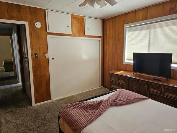 a bedroom with a bed and a flat screen tv