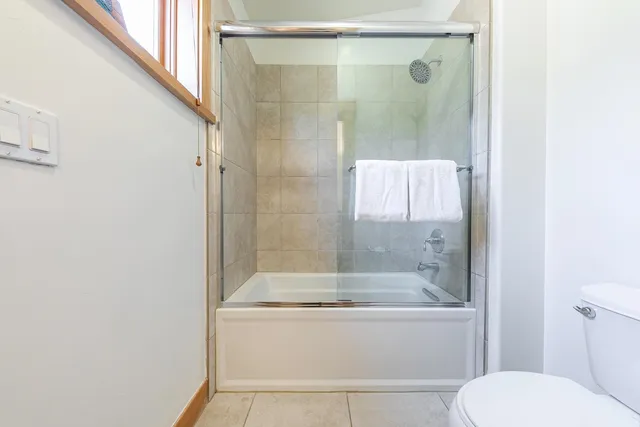a bathroom with a granite countertop bathtub shower and toilet