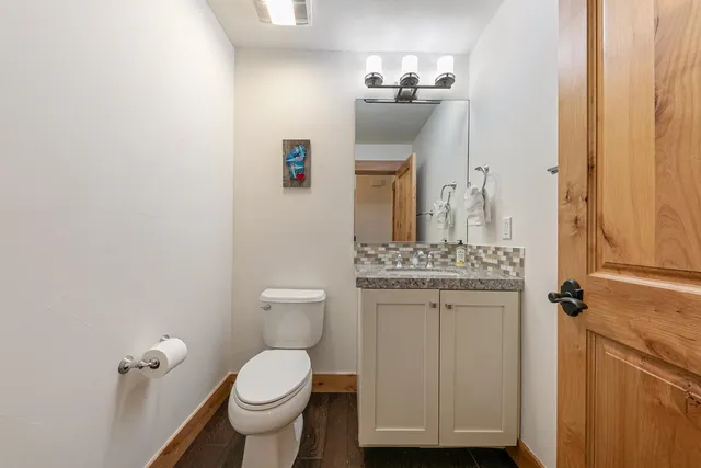a bathroom with a toilet a sink and mirror