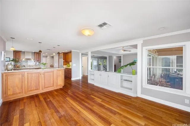 a large white kitchen with wooden floors and wide window