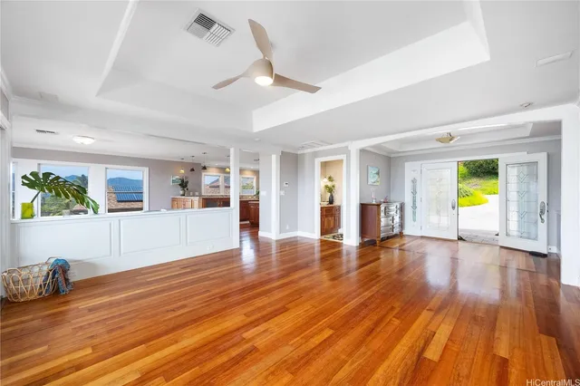 a view of an empty room with window and wooden floor