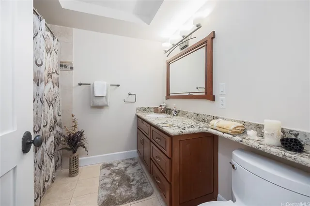 a en suite bathroom with a granite countertop sink and a mirror