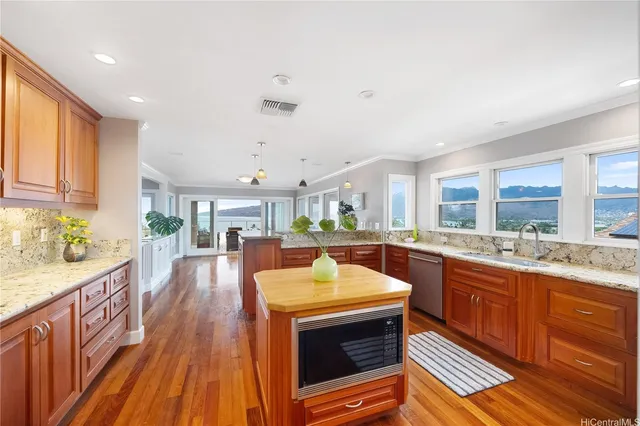 a large kitchen with stainless steel appliances granite countertop a lot of counter space and wooden floors