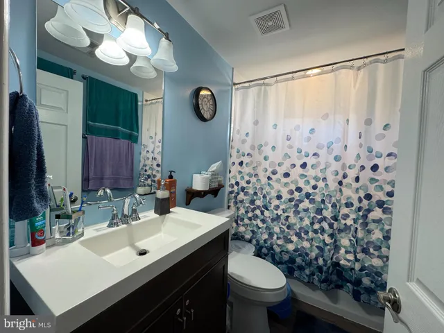 a bathroom with a sink vanity mirror and toilet