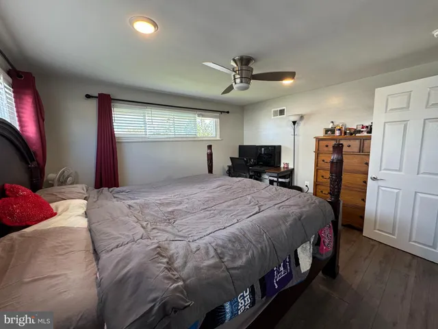 a bedroom with a large bed flat screen tv and a window