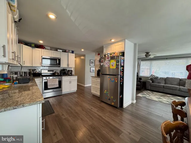 a kitchen with stainless steel appliances granite countertop a refrigerator stove microwave and sink