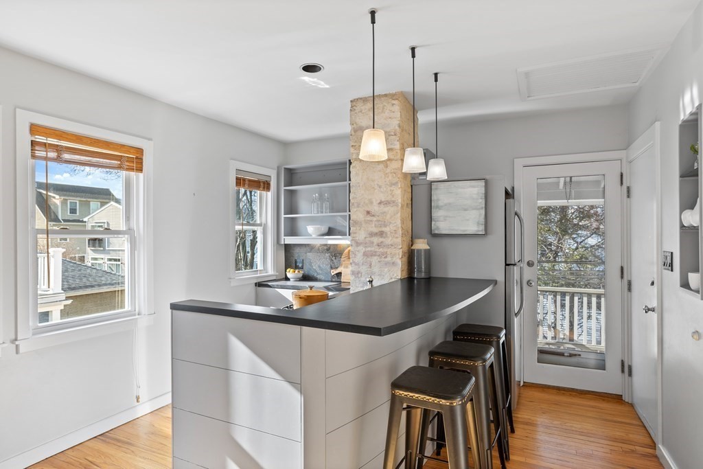 132 Rawson Road, Unit 132 Arlington, MA 02474 - Photo 13 of 26 a dining room with wooden floor and large windows