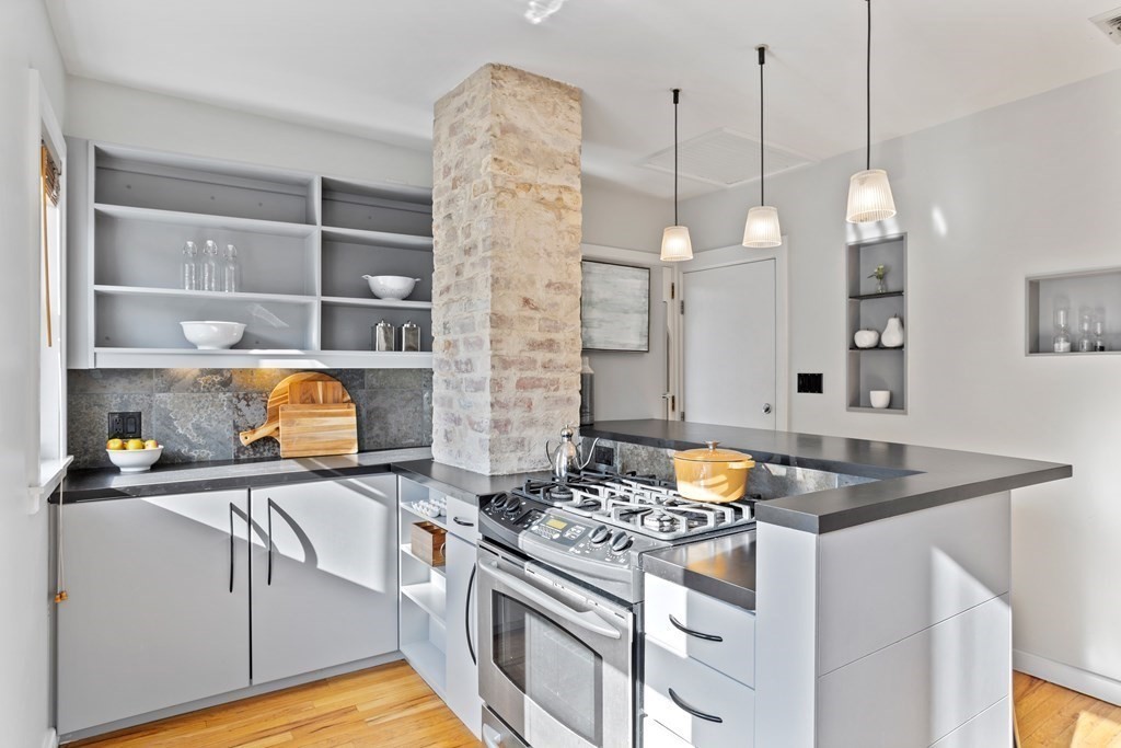 132 Rawson Road, Unit 132 Arlington, MA 02474 - Photo 14 of 26 a kitchen with stainless steel appliances granite countertop a stove a sink and a wooden floor