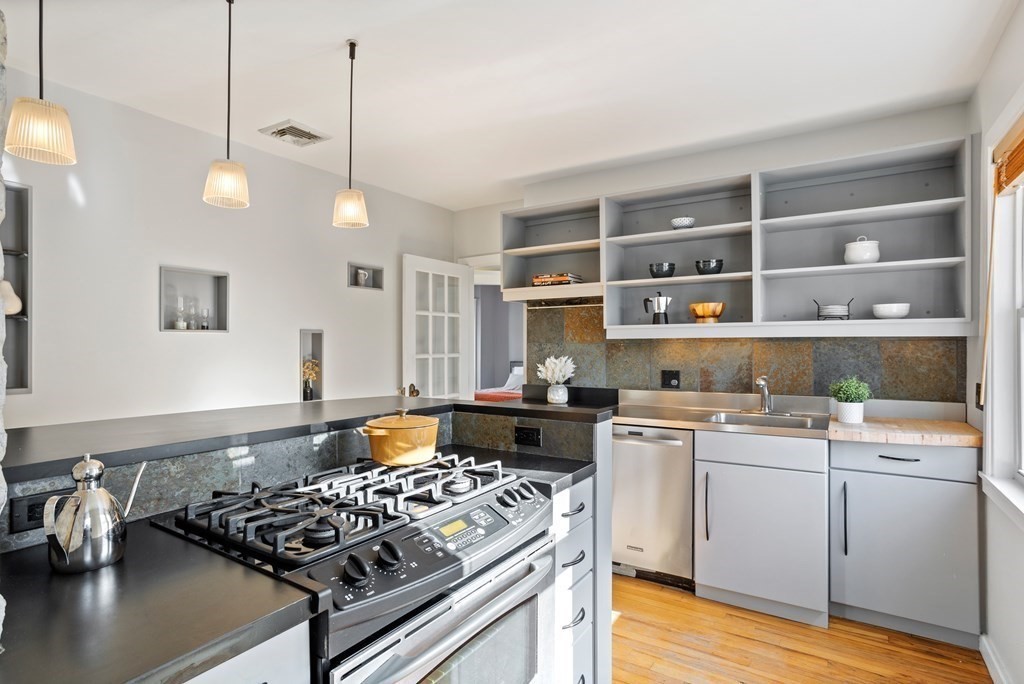 132 Rawson Road, Unit 132 Arlington, MA 02474 - Photo 15 of 26 a kitchen with a stove and wooden floor